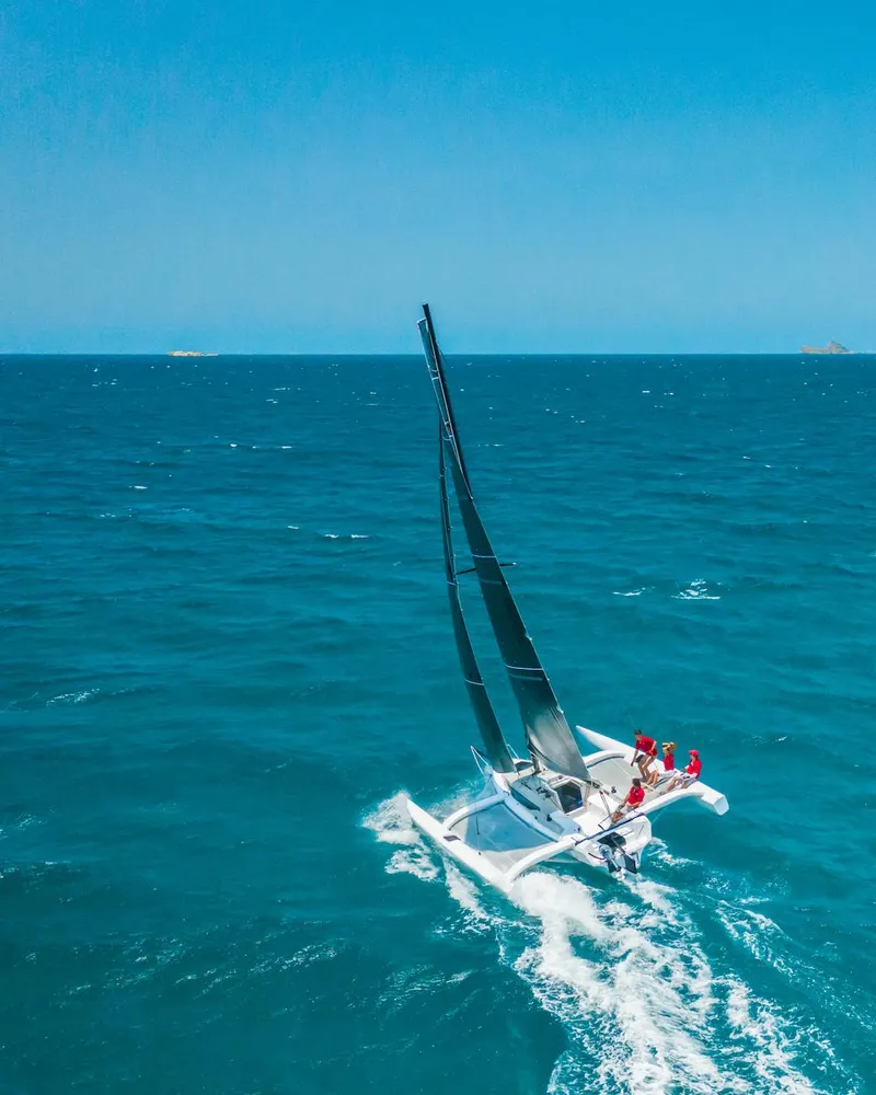 The Image of Sailing Corsair 880 trimaran on open sea, 2025 model, under clear blue sky. - 0
