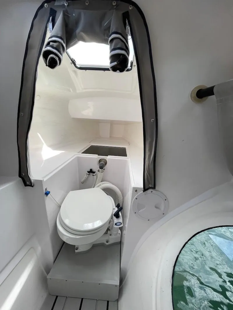 Slide: The Image of Compact bathroom in 2025 Corsair 880 boat, featuring modern marine toilet and sleek design. - 21