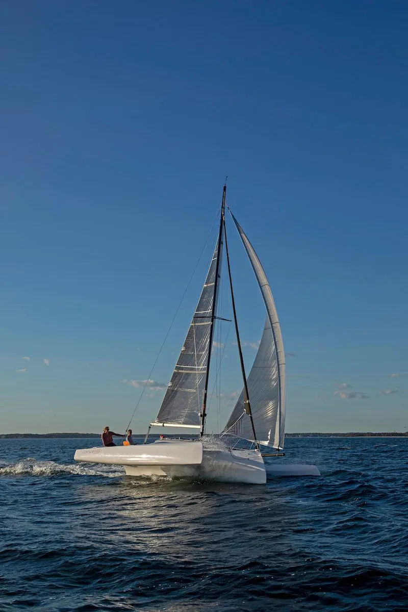 Slide: The Image of 2025 Corsair 880 sailboat navigating open waters under clear blue skies. - 3
