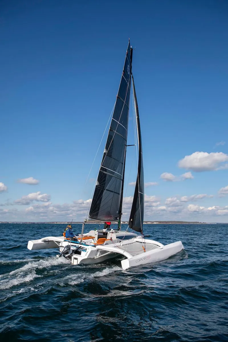 Slide: The Image of 2025 Corsair 880 sailboat navigating open waters under clear blue skies. - 4