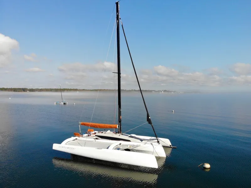 Slide: The Image of 2025 Corsair 880 catamaran sailing on calm waters under a clear sky. - 6