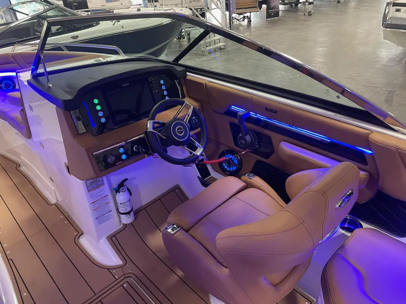 Slide: The Image of 2025 Chaparral 267 SSX boat interior with modern dashboard and leather seats. - 13