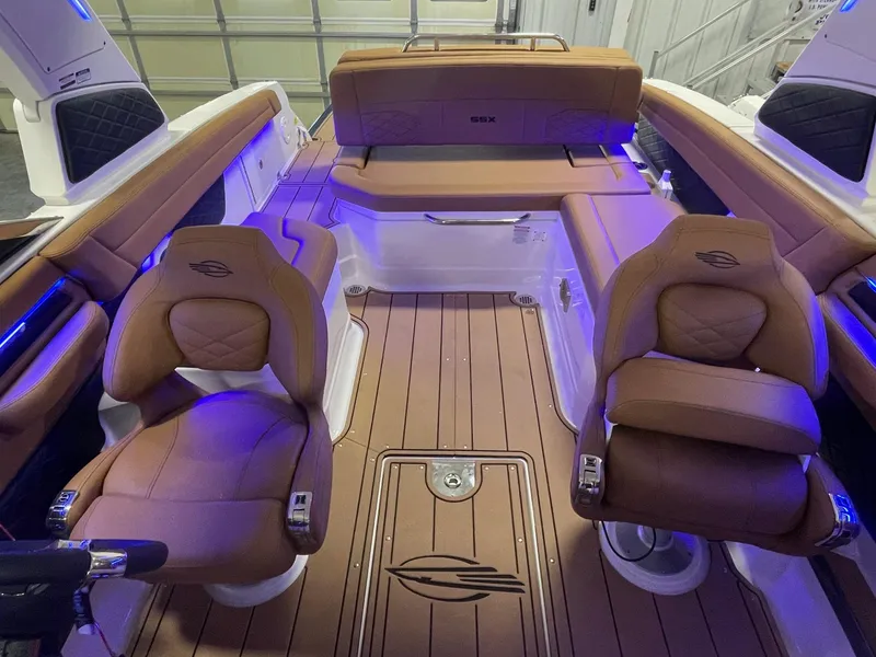 Slide: The Image of 2025 Chaparral 267 SSX boat interior with brown leather seats and wood flooring. - 8