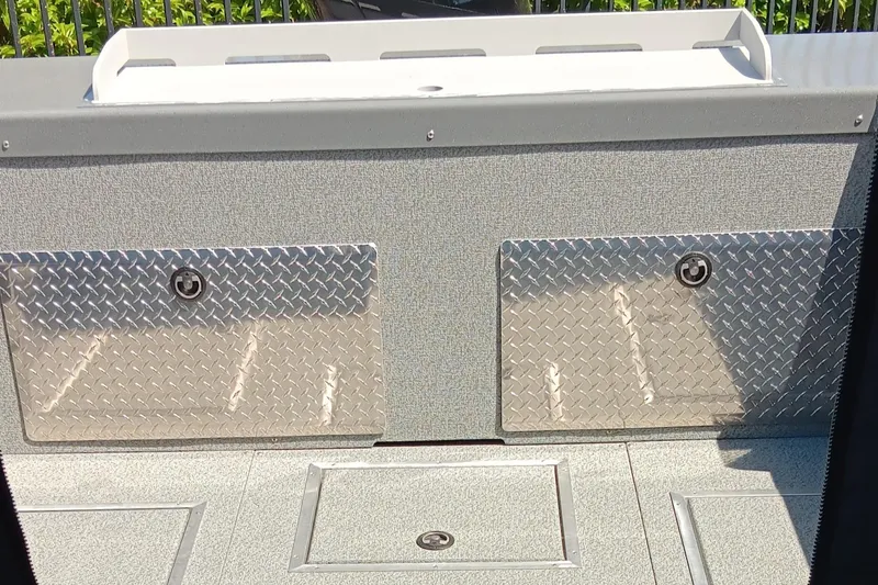 Slide: The Image of 2025 Spartan 200 Astoria boat storage compartments with diamond plate covers. - 5