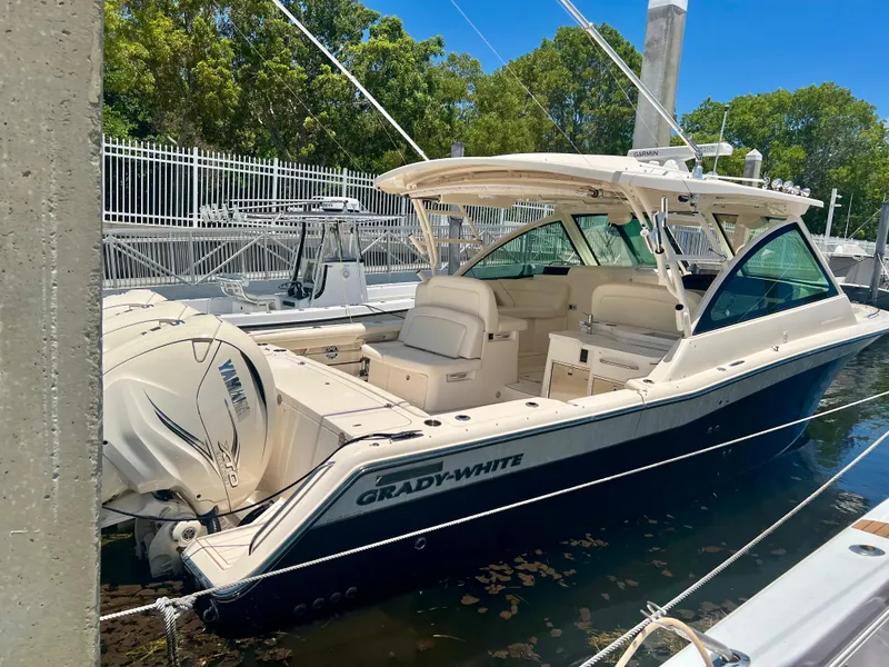 Slide: The Image of 2021 Grady-White Freedom 375 boat docked, featuring spacious seating and twin Yamaha outboard engines. - 8