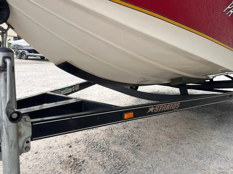 Slide: The Image of 2007 Stratos 176XT boat on trailer, red and white hull, parked on gravel. - 17