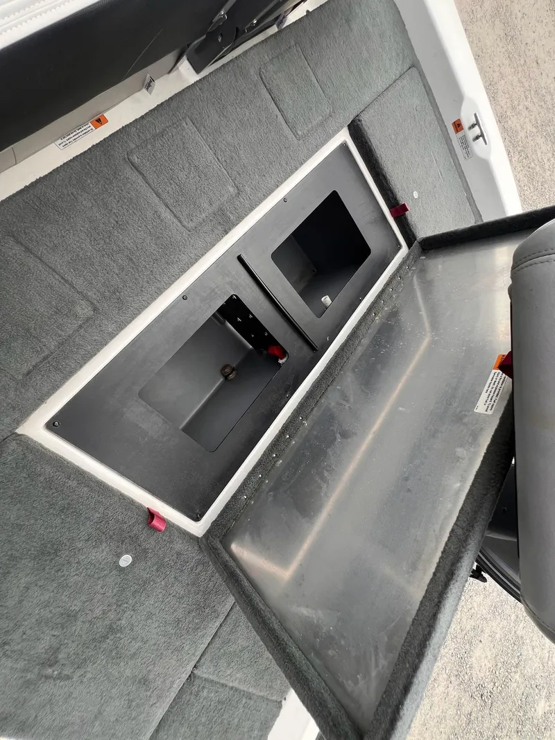 Slide: The Image of Open storage compartment in a 2007 Stratos 176XT boat, featuring carpeted interior. - 19