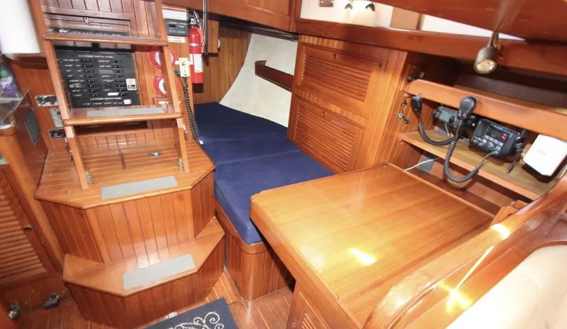 Slide: The Image of 1984 Tayana Sloop Rigged Cutter interior with wooden finish and navigation equipment. - 12