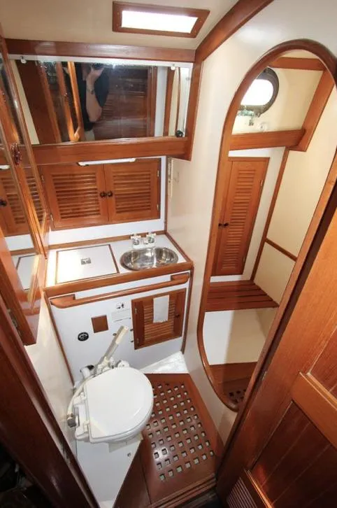 Slide: The Image of 1984 Tayana Sloop Rigged Cutter bathroom with wooden cabinetry and compact design. - 15