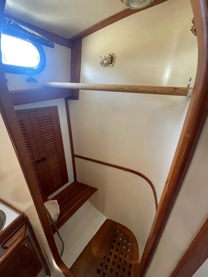 Slide: The Image of 1984 Tayana Sloop Rigged Cutter interior with wooden accents and storage space. - 19