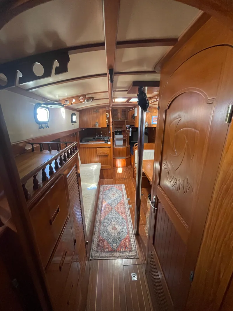Slide: The Image of 1984 Tayana Sloop Rigged Cutter interior with wooden finish and nautical decor. - 21