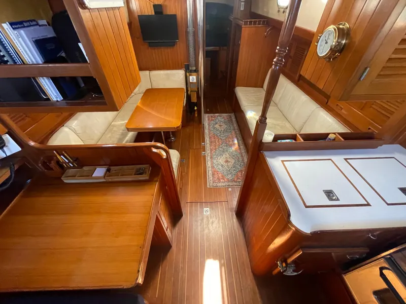 Slide: The Image of Interior of 1984 Tayana Sloop Rigged Cutter, featuring wood paneling and cozy seating area. - 27