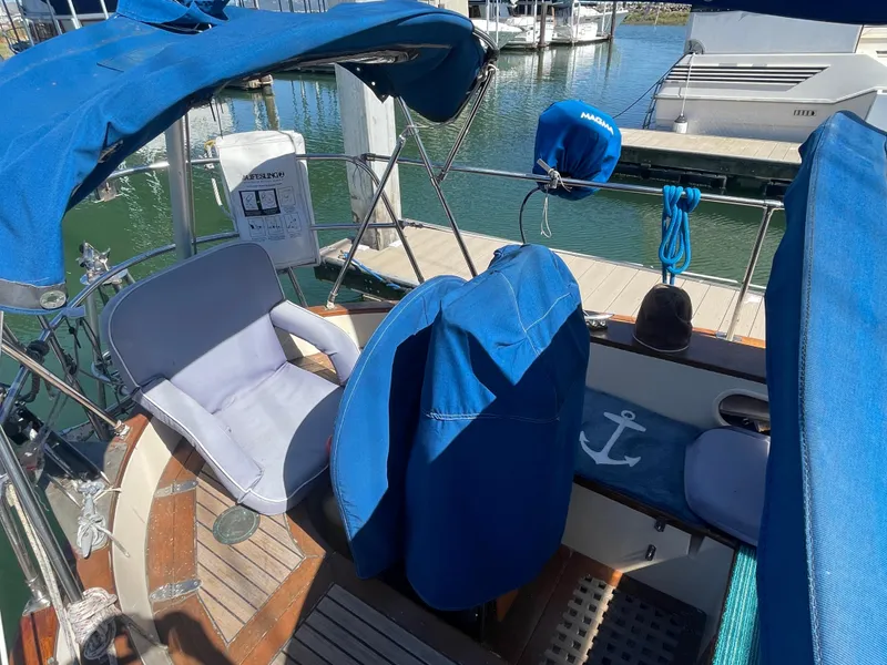 Slide: The Image of 1984 Tayana Sloop Rigged Cutter with blue covers docked at marina. - 3