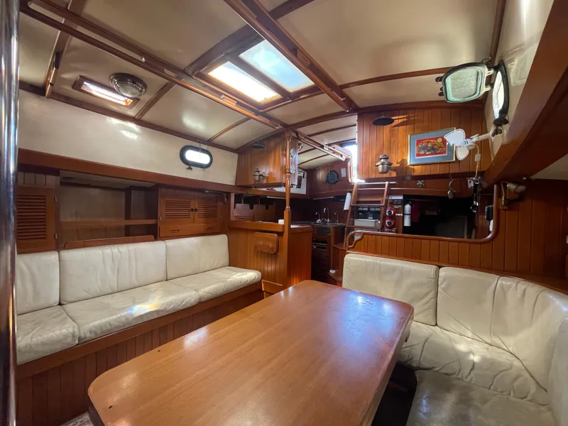 Slide: The Image of Interior of 1984 Tayana Sloop Rigged Cutter, featuring cozy seating and wooden finishes. - 30