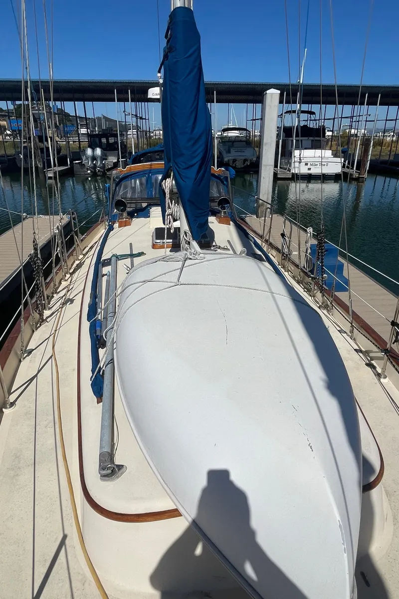 Slide: The Image of 1984 Tayana Sloop Rigged Cutter docked at a marina, showcasing its deck and mast. - 5