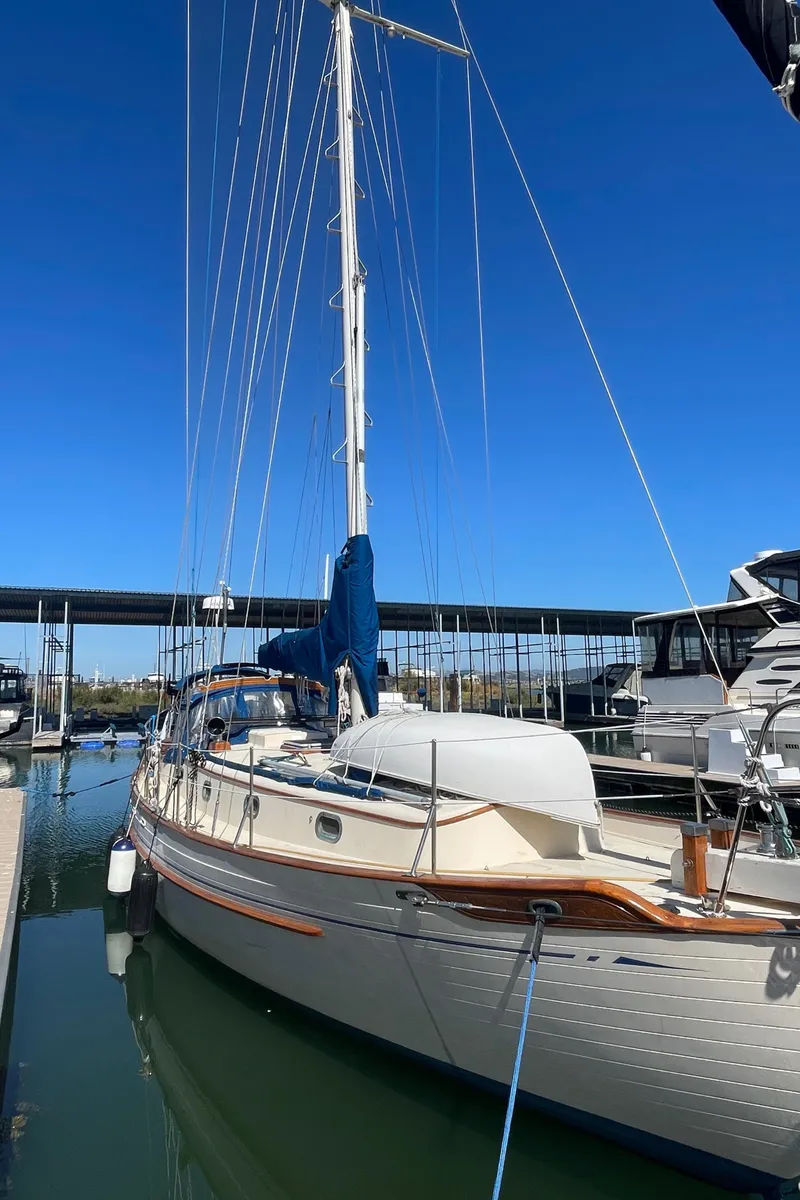 Slide: The Image of 1984 Tayana Sloop Rigged Cutter docked at marina under clear blue sky. - 7