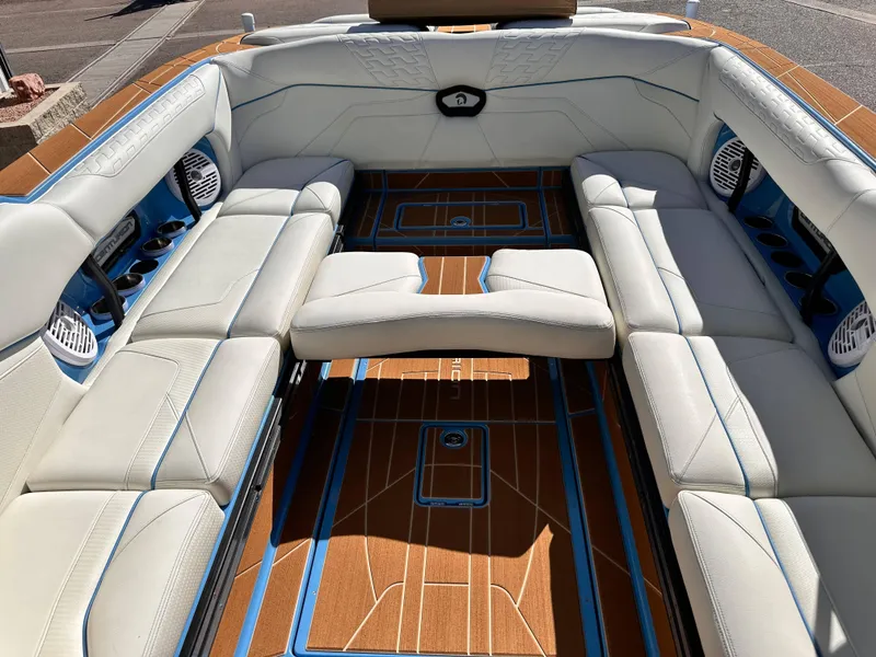 Slide: The Image of 2024 Centurion Ri265 boat interior with white leather seating and teak flooring. - 11
