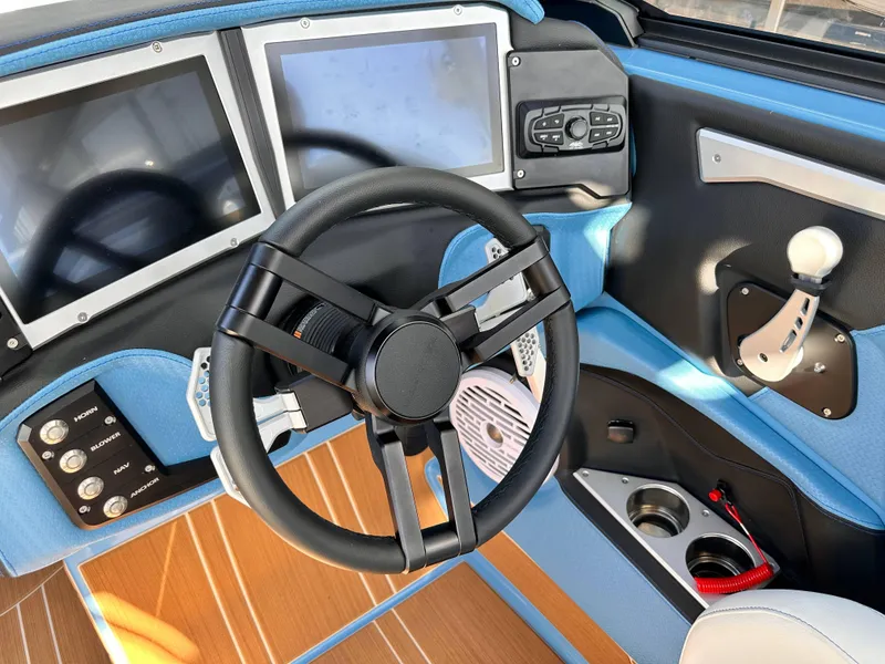Slide: The Image of 2024 Centurion Ri265 boat dashboard with dual screens, steering wheel, and control panel. - 5
