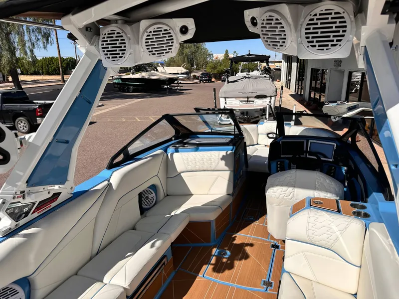 Slide: The Image of 2024 Centurion Ri265 boat interior with white leather seats and advanced audio system. - 9