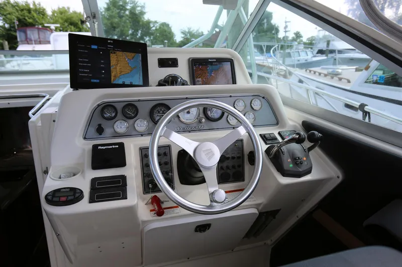 Slide: The Image of 2005 Wellcraft 330 Coastal boat helm with navigation screens and controls. - 10