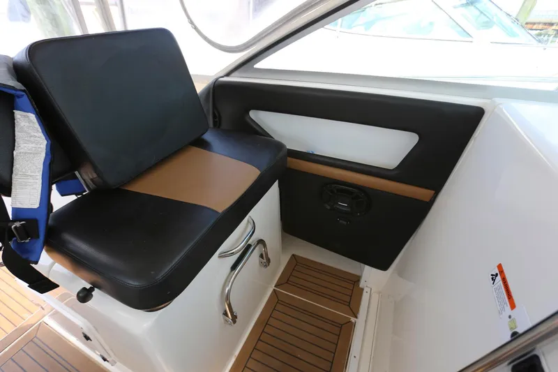 Slide: The Image of 2005 Wellcraft 330 Coastal boat interior seating area with black and brown cushioned seat. - 14