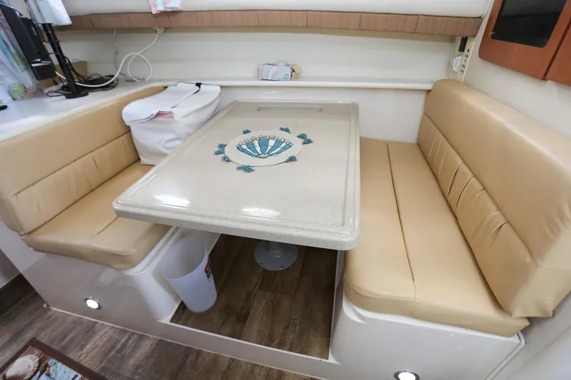 Slide: The Image of 2005 Wellcraft 330 Coastal interior dining area with beige seating and decorative table. - 17