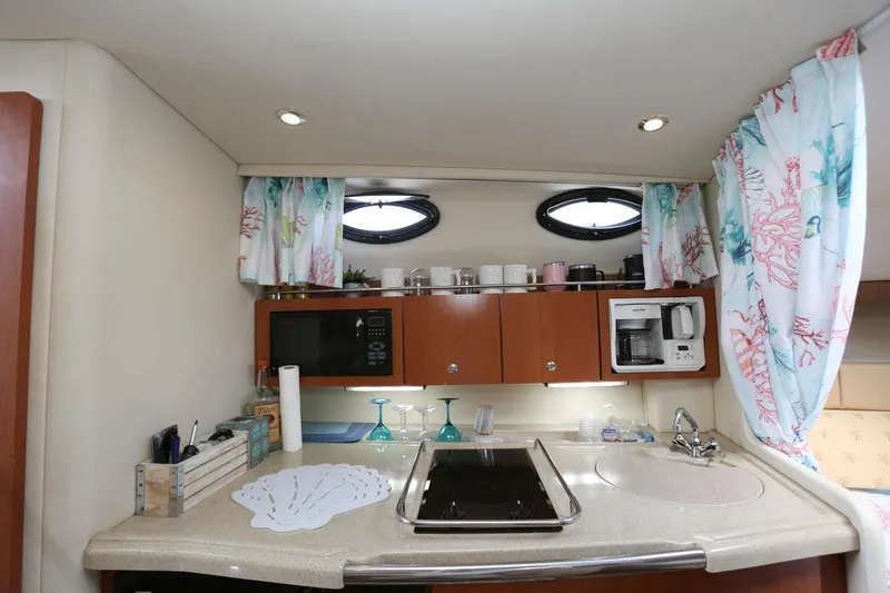 Slide: The Image of 2005 Wellcraft 330 Coastal kitchen with microwave, coffee maker, and sink. - 21