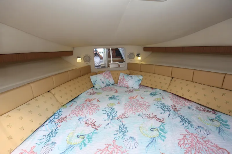 Slide: The Image of 2005 Wellcraft 330 Coastal cabin interior with colorful bedding and pillows. - 23
