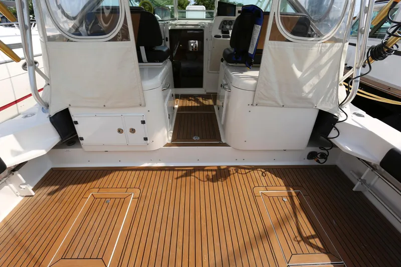 Slide: The Image of 2005 Wellcraft 330 Coastal boat cockpit with teak flooring and dual captain seats. - 5