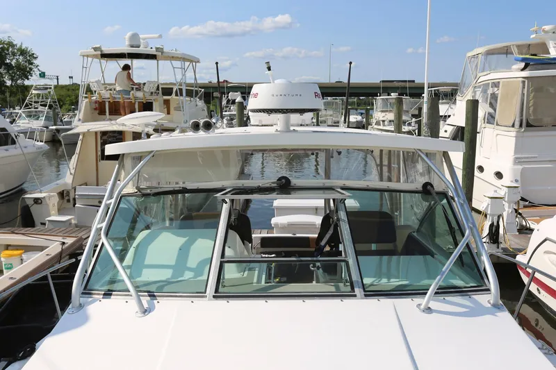 Slide: The Image of 2005 Wellcraft 330 Coastal boat docked at a marina, surrounded by other boats. - 7