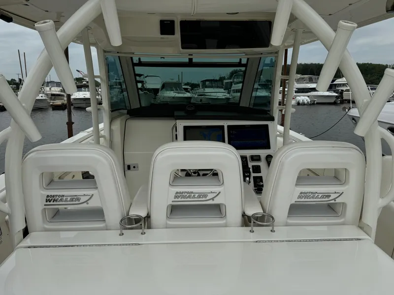 Slide: The Image of 2015 Boston Whaler 370 Outrage boat interior with helm and seating at marina. - 14