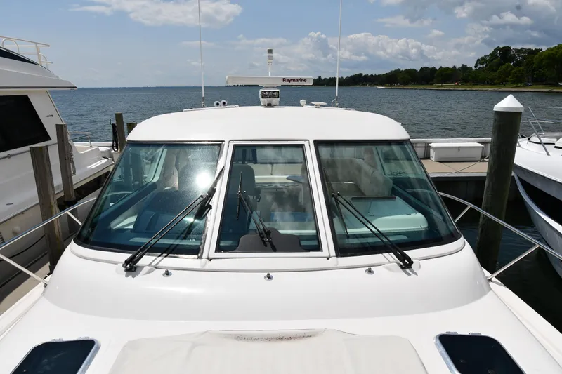 Slide: The Image of 2007 Tiara Yachts 4700 Sovran docked at a marina with a scenic water view. - 10