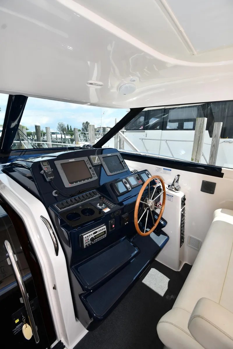 Slide: The Image of 2007 Tiara Yachts 4700 Sovran helm station with navigation equipment and wooden steering wheel. - 13
