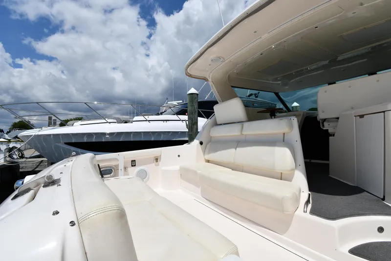 Slide: The Image of 2007 Tiara Yachts 4700 Sovran, spacious deck with white seating, docked under a partly cloudy sky. - 23