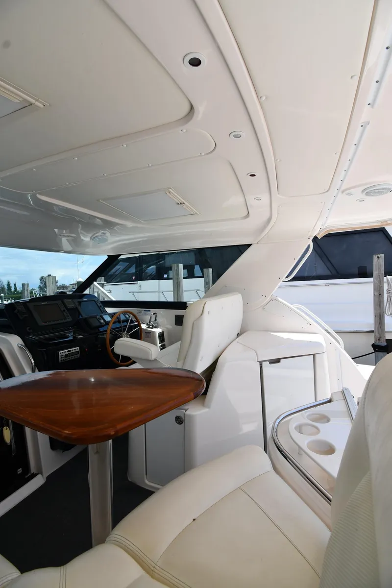 Slide: The Image of 2007 Tiara Yachts 4700 Sovran interior with helm, seating, and wooden table. - 28