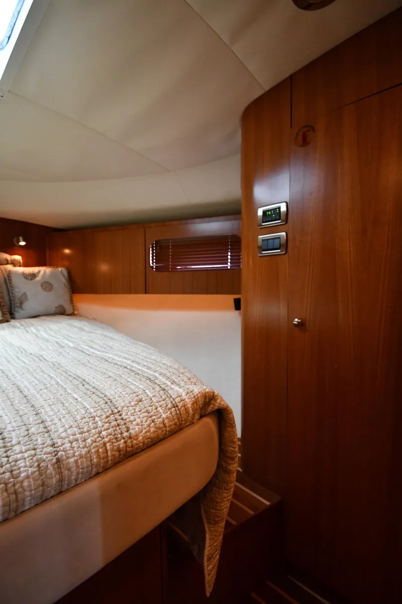 Slide: The Image of 2007 Tiara Yachts 4700 Sovran cabin interior with bed and wooden paneling. - 39