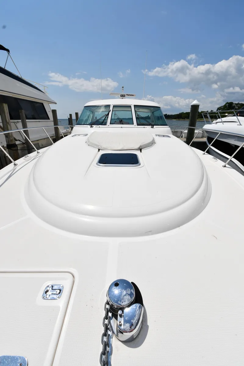 Slide: The Image of 2007 Tiara Yachts 4700 Sovran docked, front deck view under clear sky. - 8