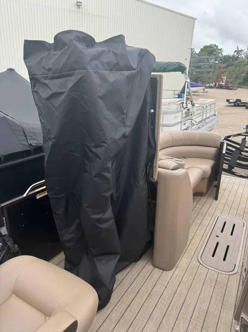 Slide: The Image of 2021 Veranda VTX25RC pontoon boat interior with covered equipment and beige seating. - 10