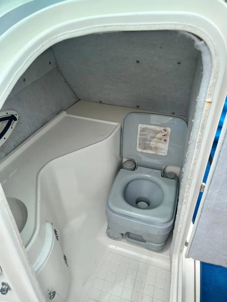 Slide: The Image of 2001 Wellcraft 260 Excalibur Sport boat interior bathroom with portable toilet. - 8