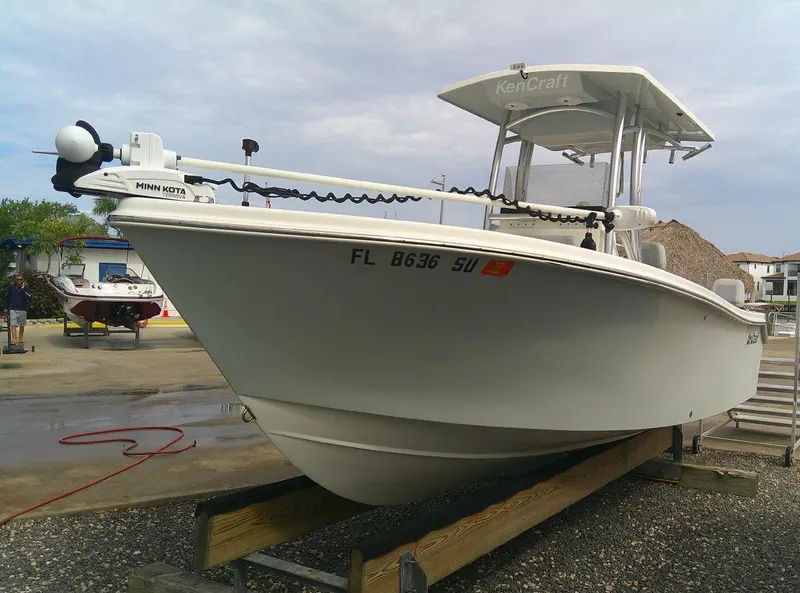 Slide: The Image of 2020 KenCraft Challenger 21 boat on a trailer at a marina. - 2