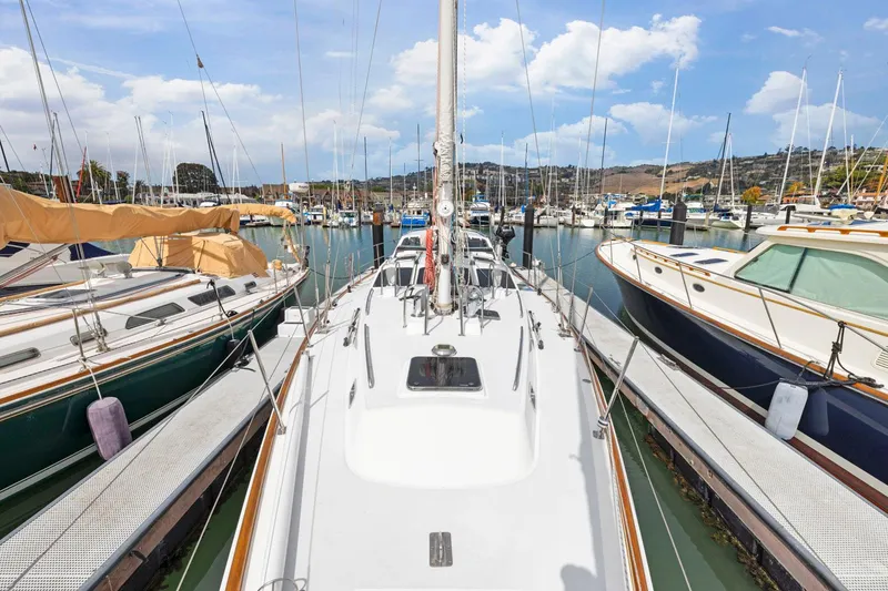 Slide: The Image of Sailboat docked in marina, surrounded by other boats, under a clear blue sky. - 18