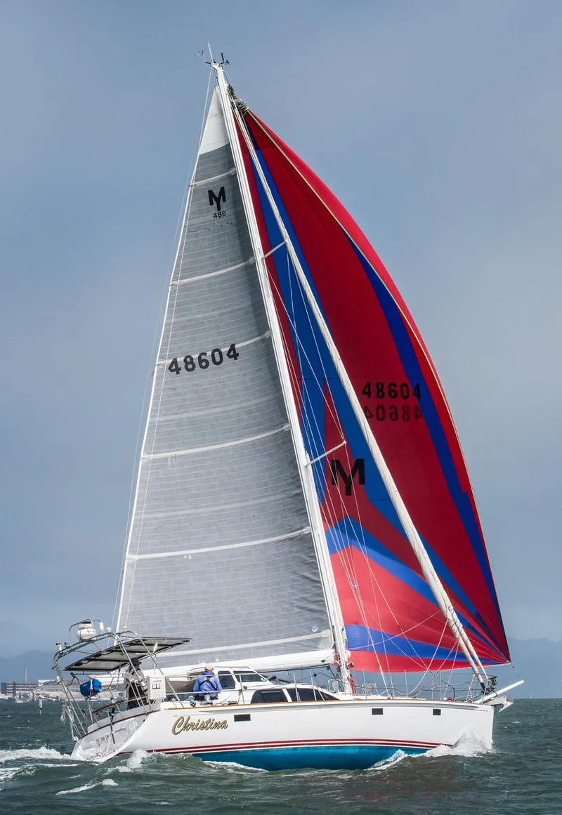Slide: The Image of Sailing yacht Morris 486, 2005 model, with vibrant red and blue sails on open water. - 3