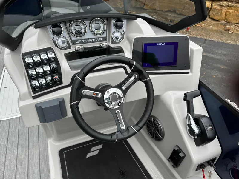 Slide: The Image of 2024 Starcraft MX 25 R boat dashboard with steering wheel and control panel. - 12