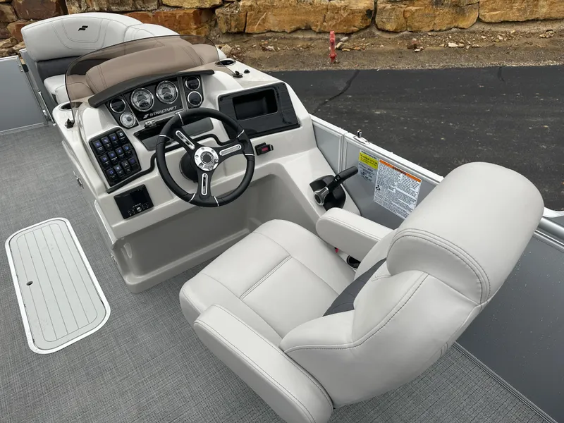 Slide: The Image of 2024 Starcraft MX 25 R boat cockpit with steering wheel and captain's chair. - 8