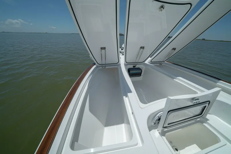Slide: The Image of 2024 Valhalla Boatworks V-28 storage compartments open on calm water. - 16
