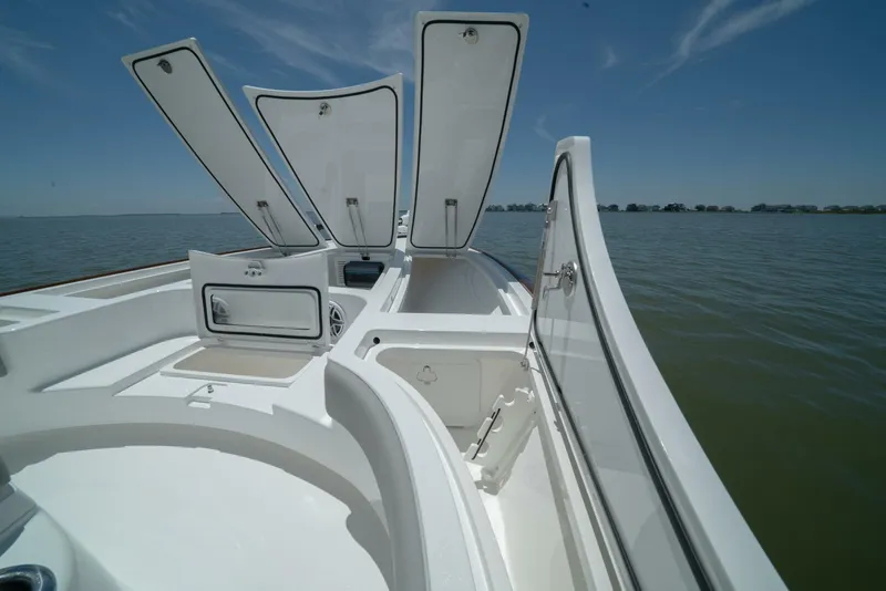 Slide: The Image of 2024 Valhalla Boatworks V-28 with open storage compartments on a calm lake. - 19