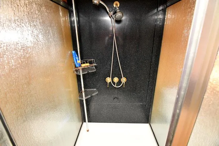 Slide: The Image of Shower area in 1997 Forbes Cooper 74 Pilothouse yacht with black walls and chrome fixtures. - 23
