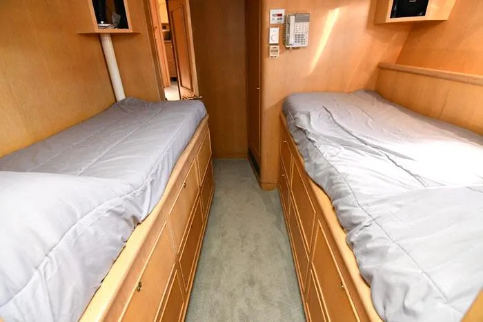 Slide: The Image of Twin beds in a 1997 Forbes Cooper 74 Pilothouse cabin, featuring wooden storage drawers. - 31
