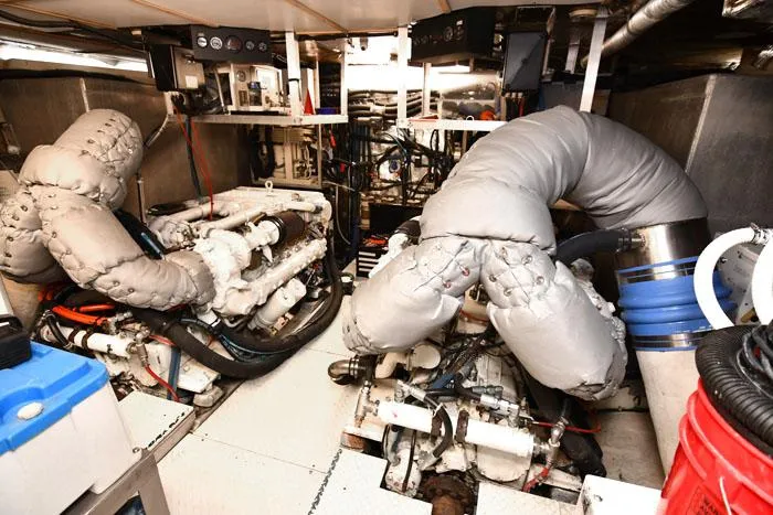Slide: The Image of Engine room of 1997 Forbes Cooper 74 Pilothouse yacht, featuring insulated machinery and complex piping. - 38