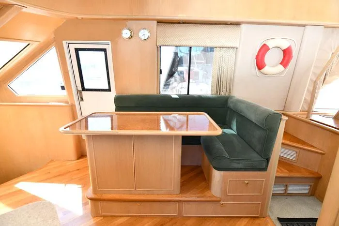 Slide: The Image of Interior of 1997 Forbes Cooper 74 Pilothouse yacht with dining area and green seating. - 7